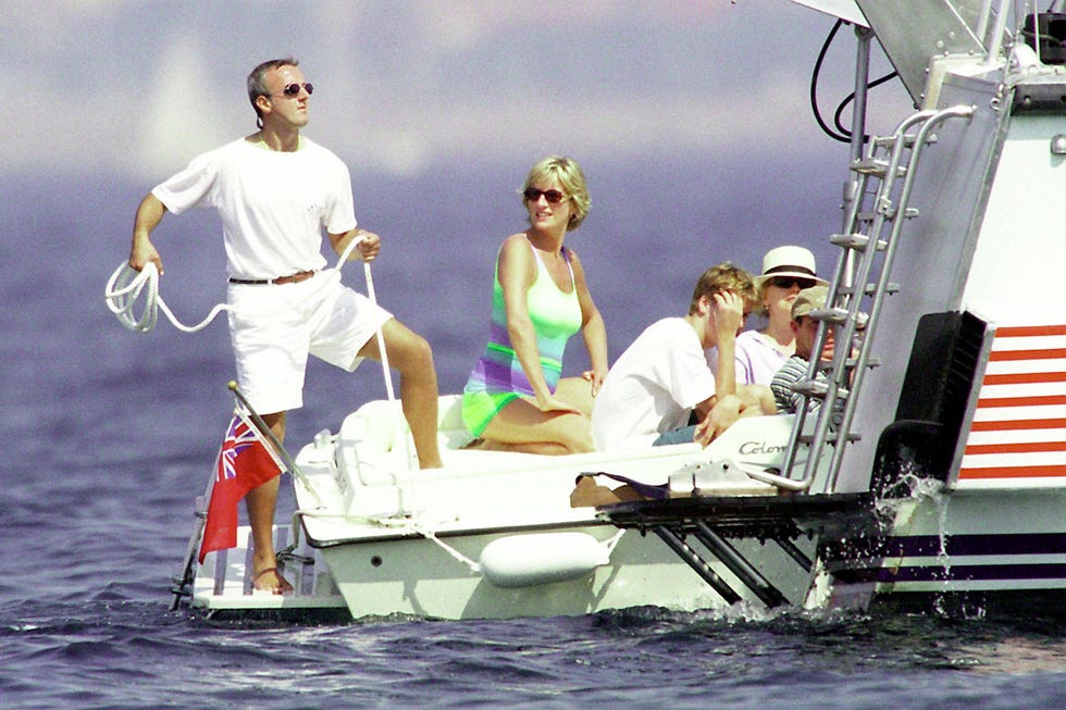 several people in beaching clothes sitting in the back of a boat, wearing sunglasses