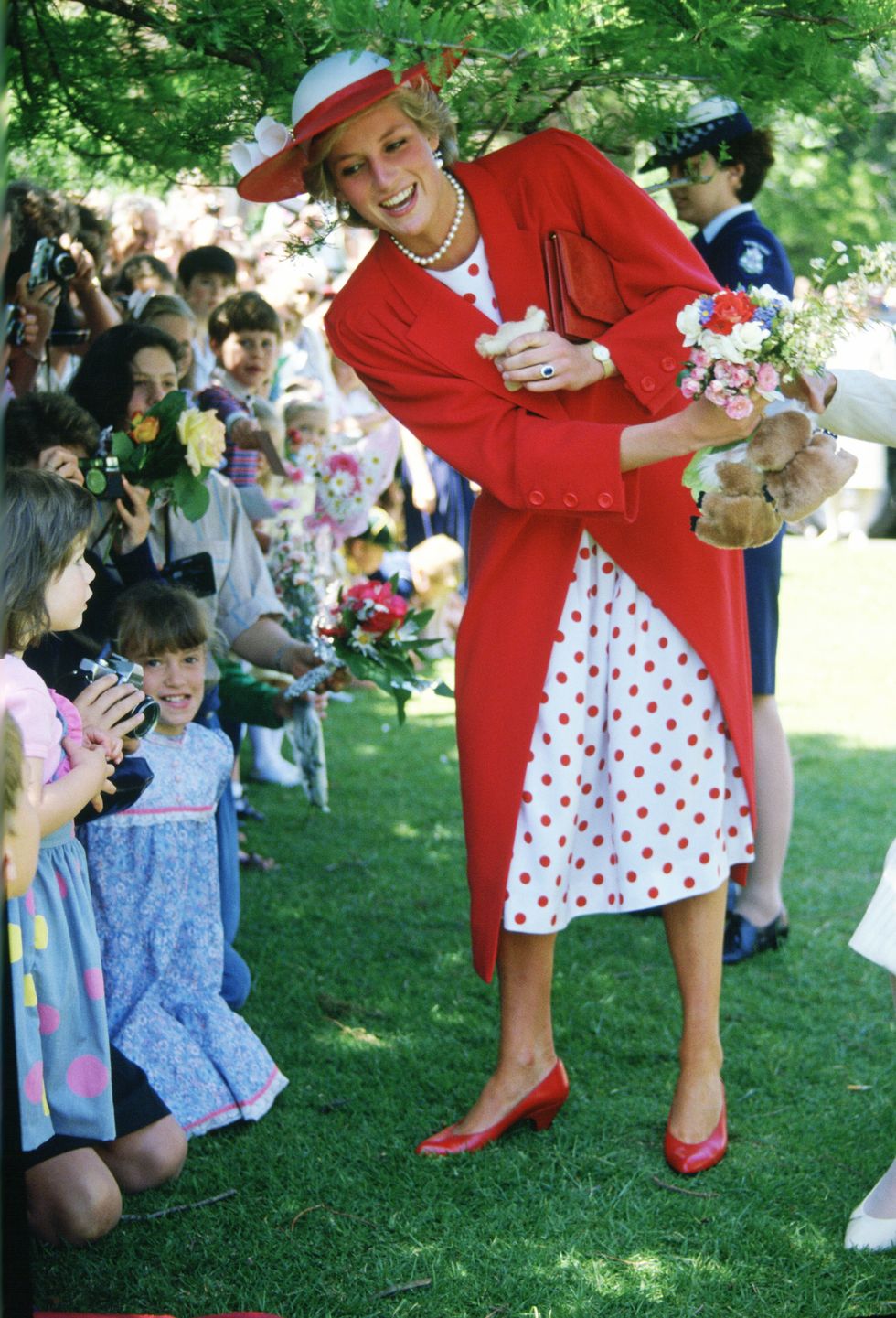 Diana, Princess of Wales hands the flowers she receives from