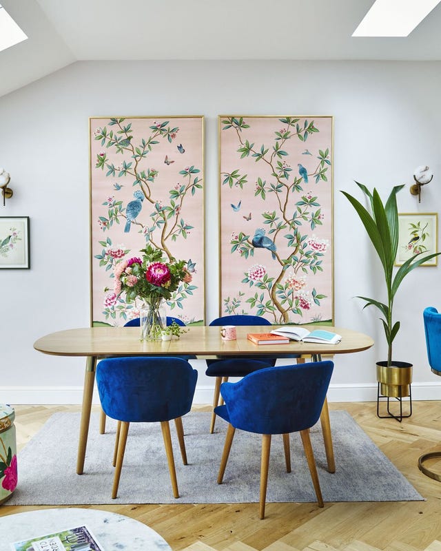 a table with chairs and a vase with flowers on it