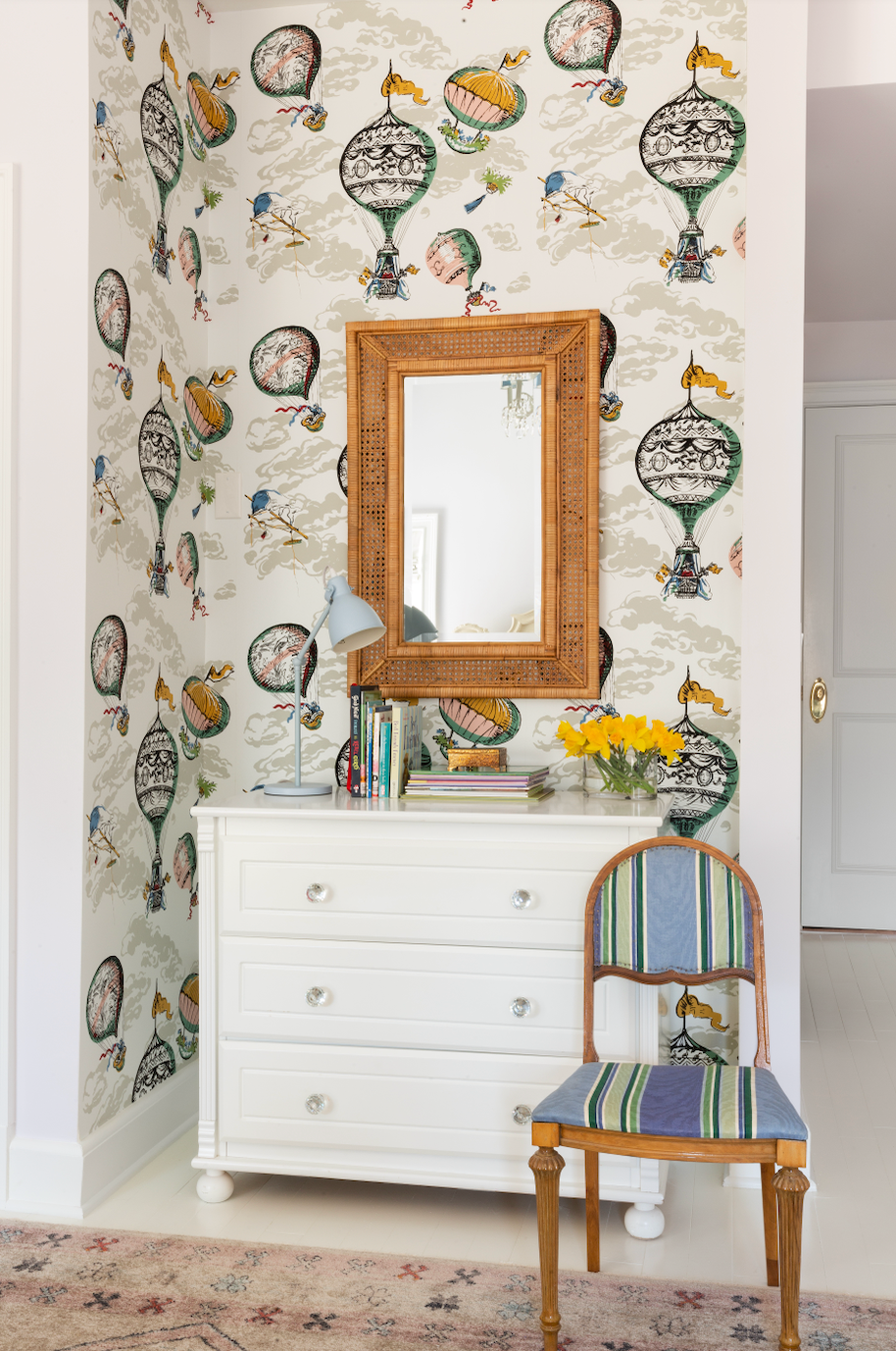 a white dresser with a mirror and a chair in front of it