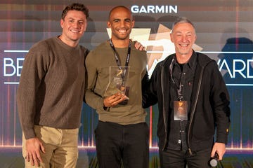 Three individuals celebrating an award presentation