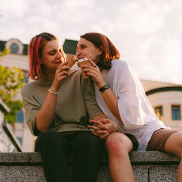 twee vrouwen eten hand in hand een ijsje en lachen