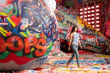 Model walking through a colorful graffiticovered space
