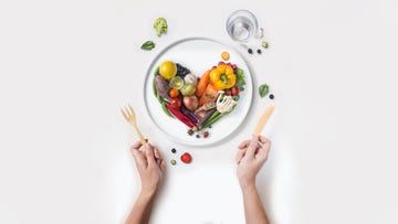 heart shape pile of sliced raw vegan food served on white background
