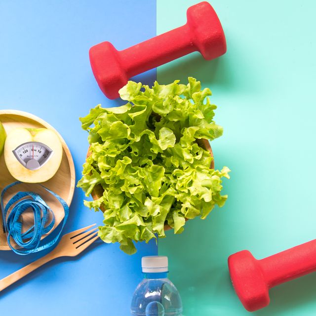 Diet slimming weight with green apple and measuring tap, scale weight on the wood plate, vegetables, dumbbells, colourful background.  Diet and Healthy Concept