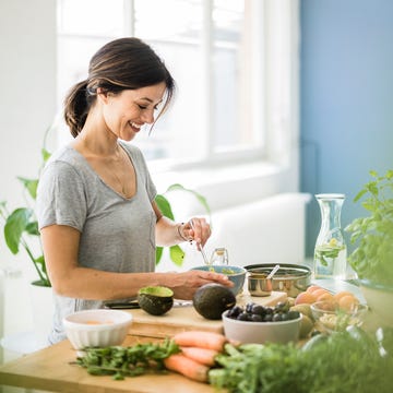 Woman preparing healthy food in her kitchen dieta para mujeres de 40
