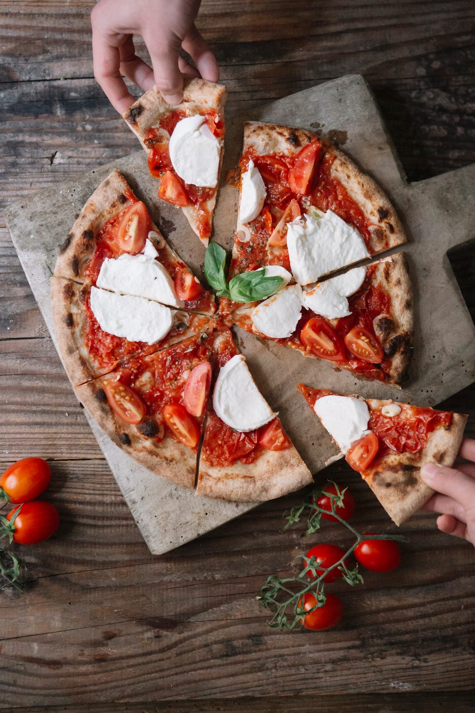 Eating a pizza with mozzarella, hand taking pizza slice