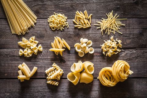 Different types of Italian pasta on rustic wooden table