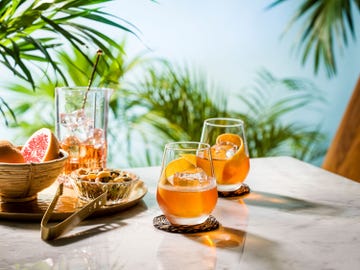 a table with glasses of liquid and fruit on it