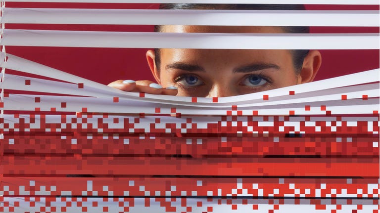 woman looking out of blinds