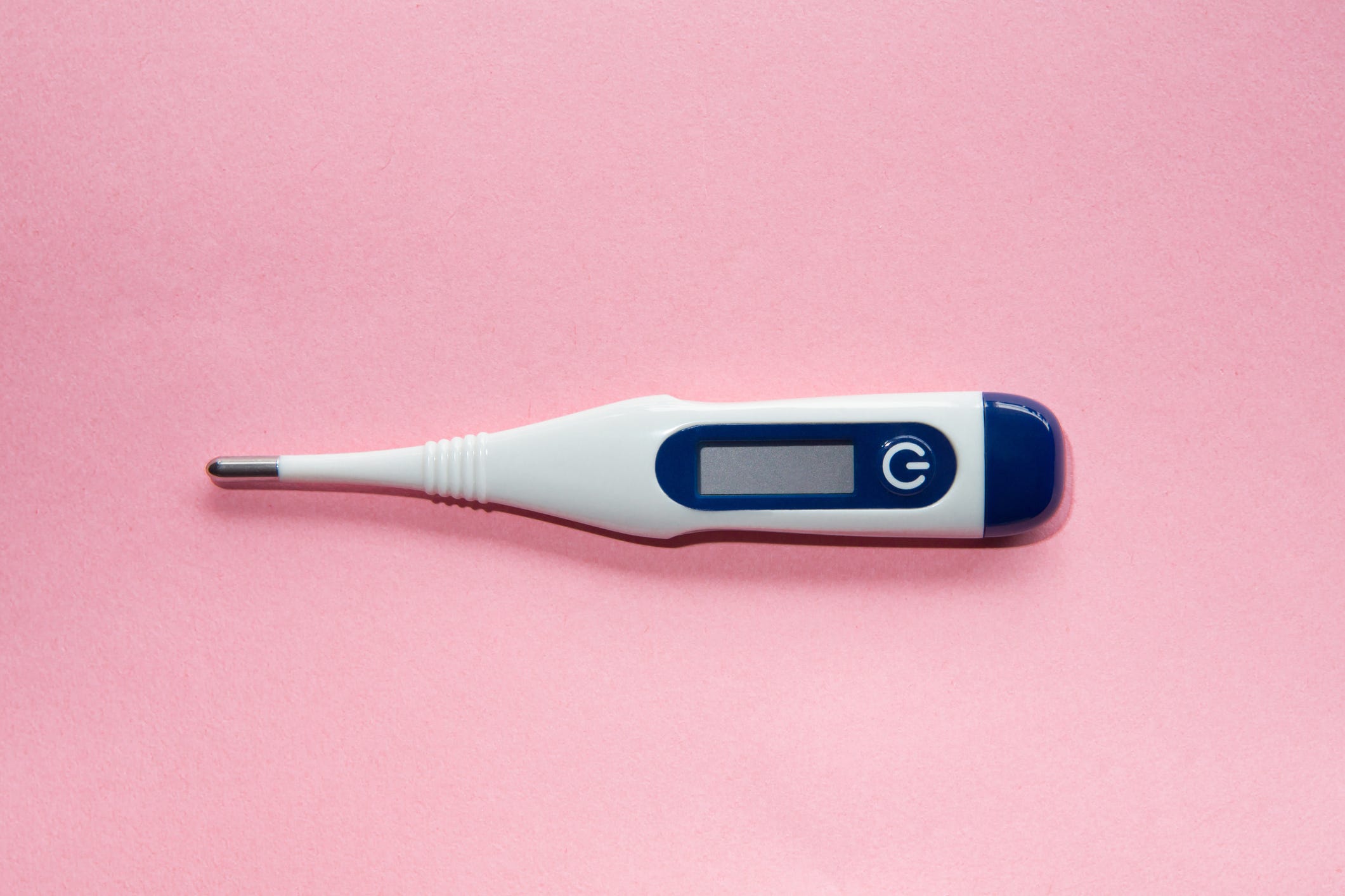 digital thermometer on pink background conceptual image for fertility, women's health and wellness