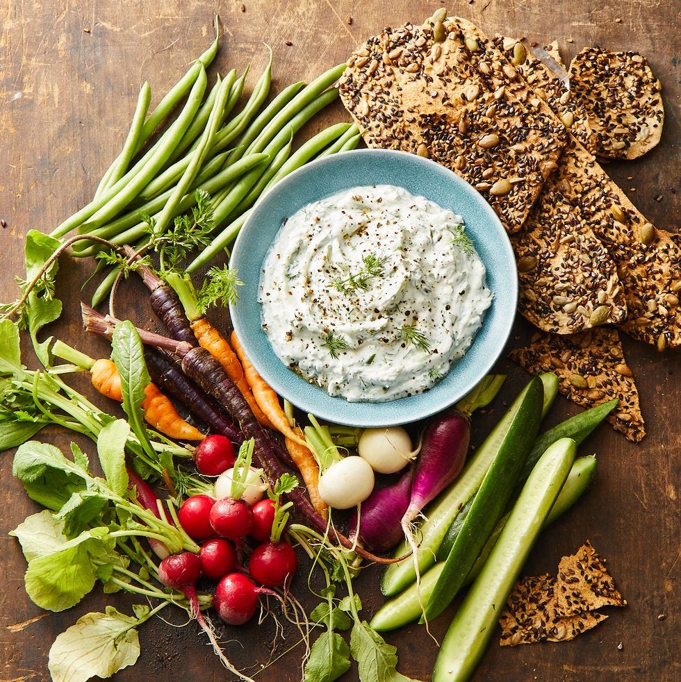 a bowl of dill dip and fresh vegetables on the side