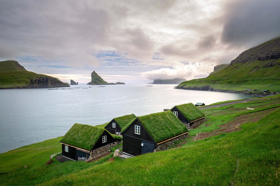 houses near the small village of B√∏ur, with Drangarnir and Tindh√≥lmur on background. Faroe Islands