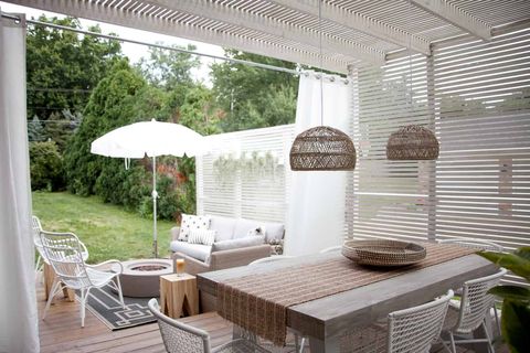slat wood pergola with wicker dining table and chairs