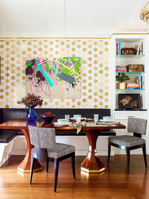 dining area with gold polka dot wallpaper and gold trim