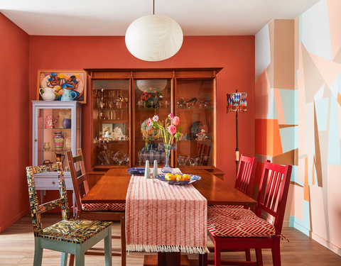 orange dining room with mismatched chairs