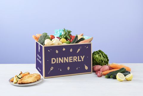 best cheap meal delivery service kit dinnerly image of a cardboard box full of vegetables with a plate of chicken breast and other colorful vegetables beside the box