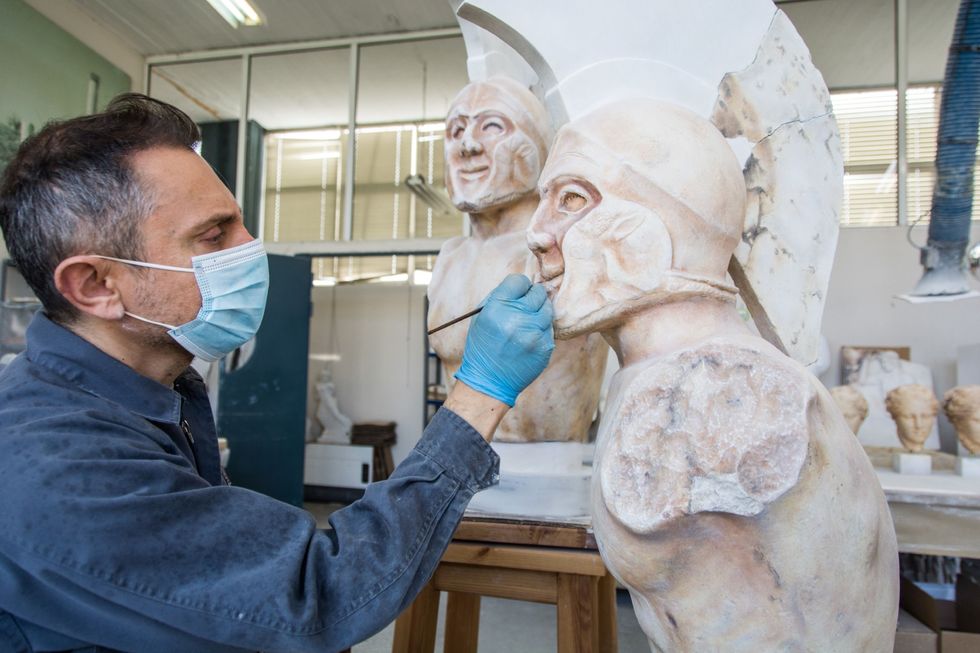 Schilder Konstantinos Kypriotakis legt de laatste hand aan een gipsafgietsel dat is gemaakt van een klassiek standbeeld van de Spartaanse krijgerkoning Leonidas