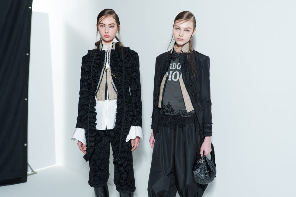 two models showcasing highfashion outfits in a minimalist setting