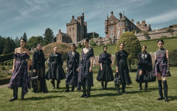 a group of models wearing dior cruise 2025 collection in clothing posing for the camera infront of drummond castle