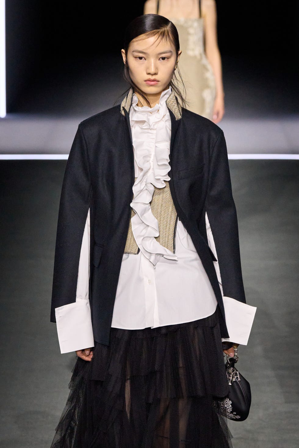fashion model wearing a layered outfit featuring ruffles and a blazer