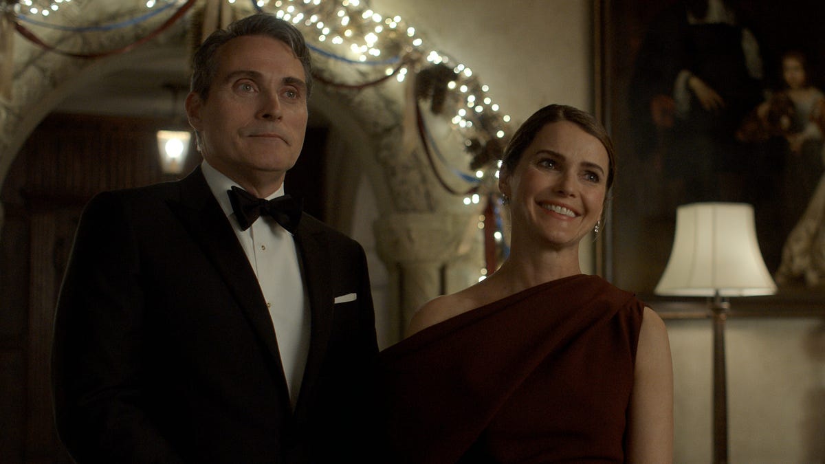 O Diplomata. (da esquerda para a direita) Rufus Sewell como Hal Wyler, Keri Russell como Kate Wyler no episódio 308 de O Diplomata. Crédito: cortesia da Netflix © 2025