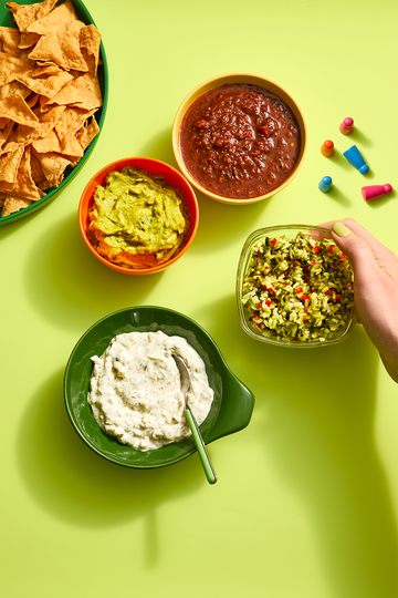 assortment of dips in bowls including salsa, guacamole and tzatziki