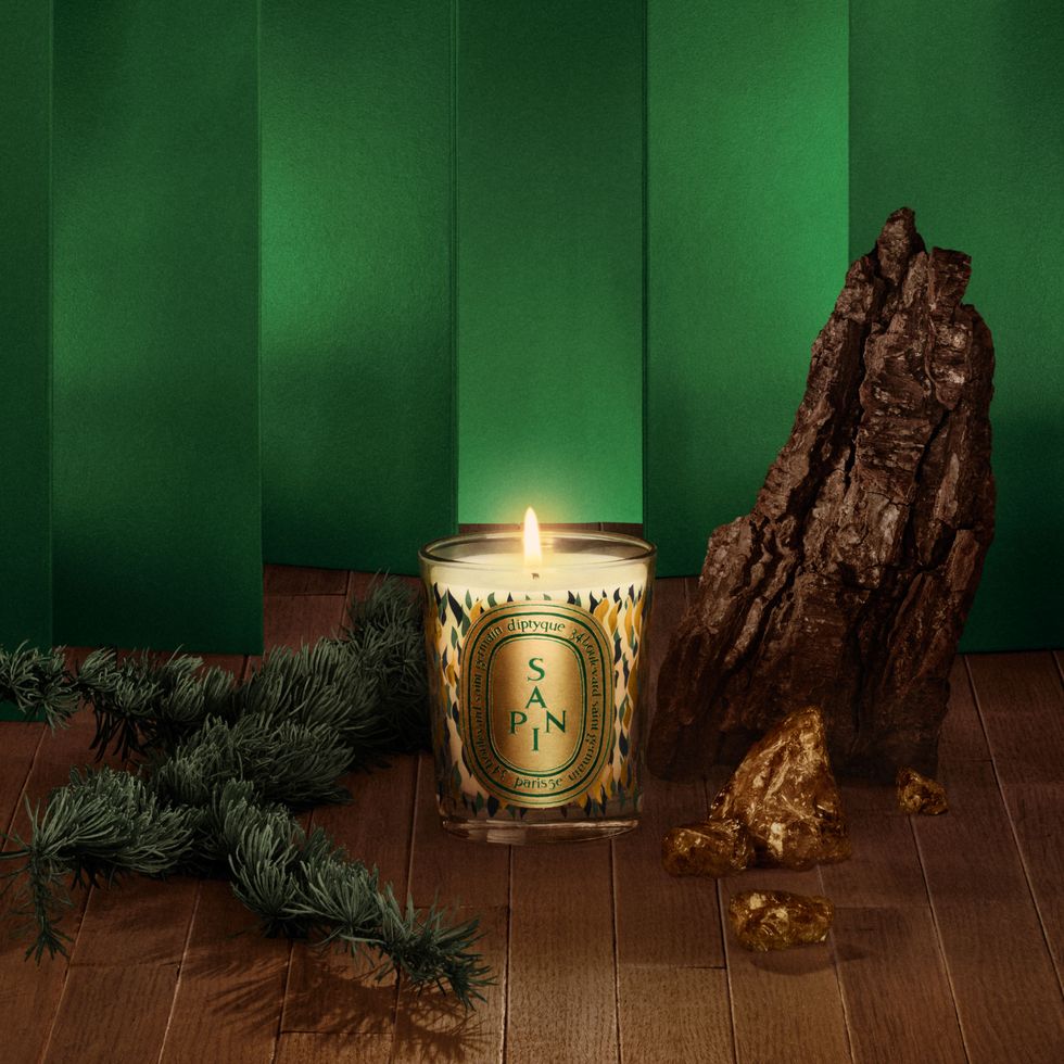 a candle and a pine cone on a table