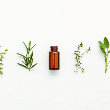 Directly Above Shot Of Bottle With Herbs On White Table