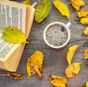directly above shot of coffee and book with autumn leaves on wooden table