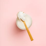 directly above shot of coconut cream in container against pink background