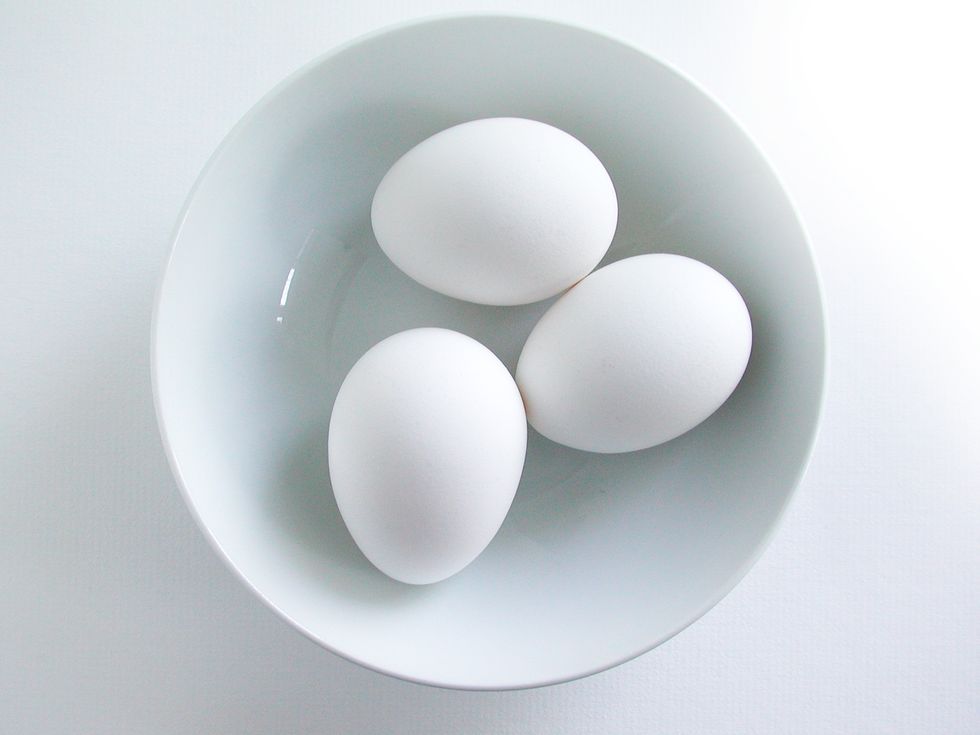 directly above shot of eggs in bowl over white background