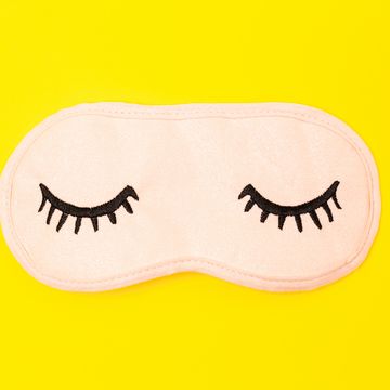 directly above shot of eye mask over yellow background