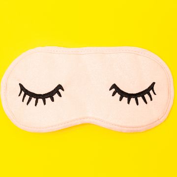 directly above shot of eye mask over yellow background