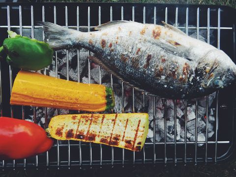 directly above shot of fish and vegetables on barbeque grill
