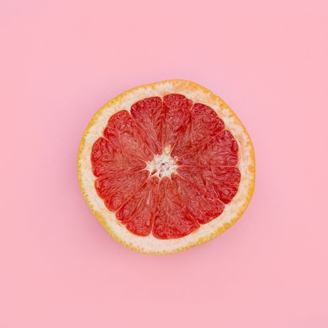 Directly Above Shot Of Grapefruit Slice Against Pink Background