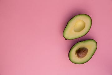 Directly Above Shot Of Halved Avocados Over Pink Background