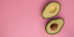 Directly Above Shot Of Halved Avocados Over Pink Background