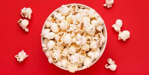 Directly Above Shot Of Popcorns In Bowl Against Red Background