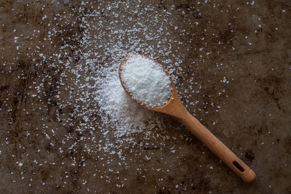 directly above shot of salt in wooden spoon on granite table