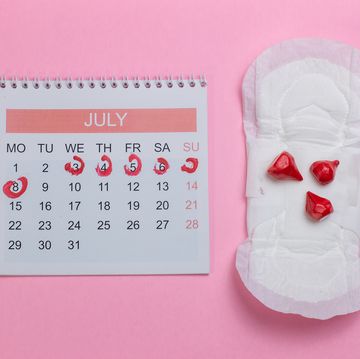directly above shot of sanitary pad by calendar over pink background