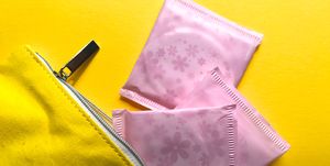 Directly Above Shot Of Sanitary Pads With Purse On Yellow Background