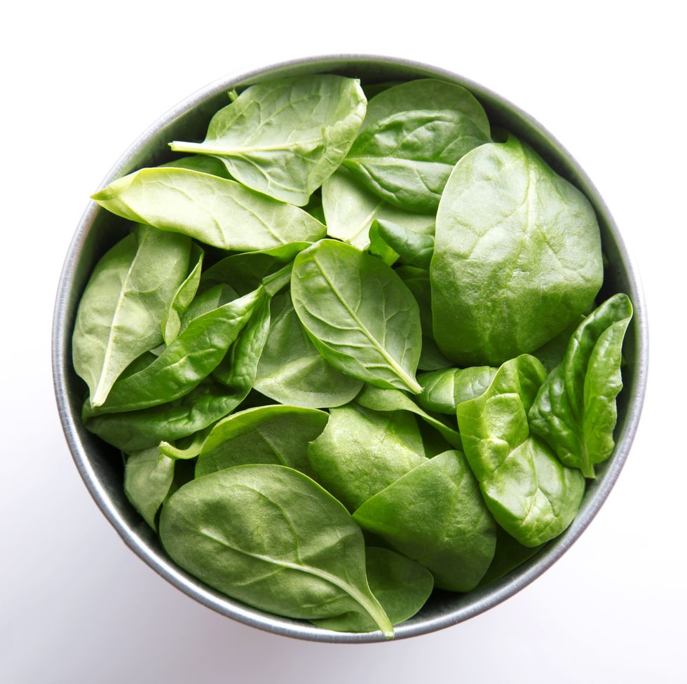Directly Above Shot Of Spinach Leaves In Container Over White Background