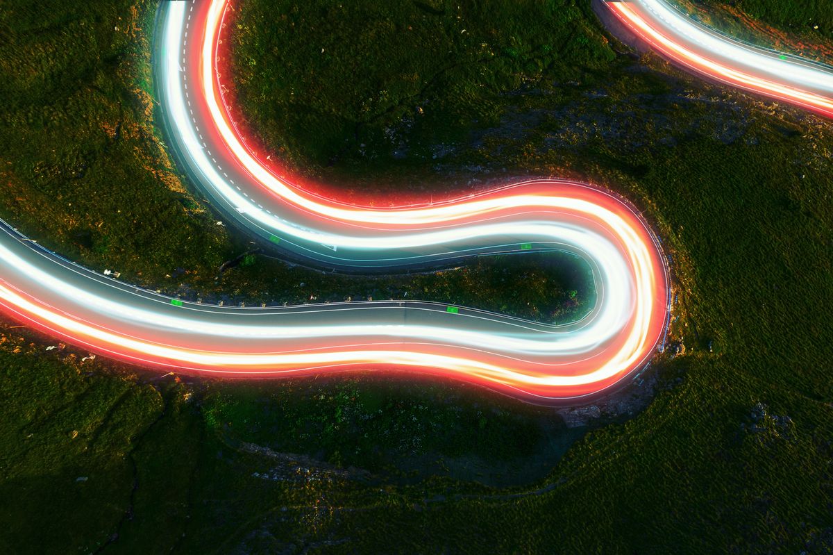 directly above view by drone of stunning colorful light trails in curvy road