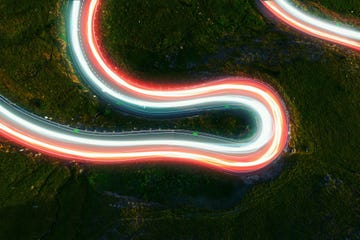 directly above view by drone of stunning colorful light trails in curvy road