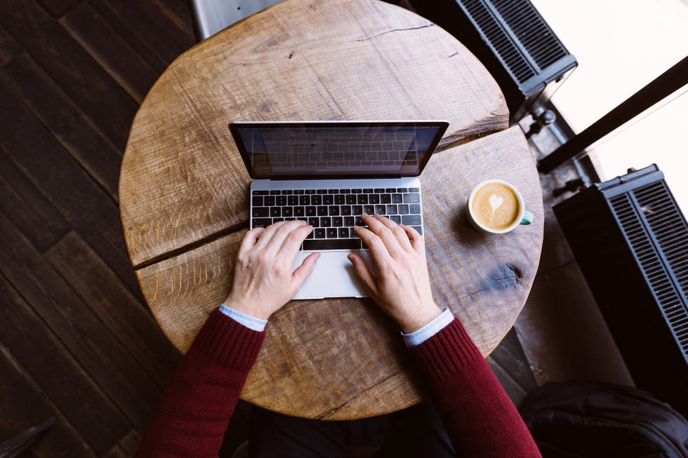 man working on laptop in coffee shop