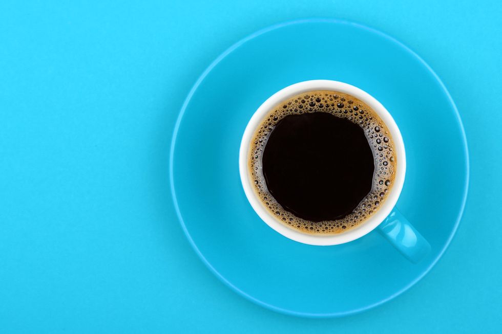 Black Coffee In Cup On Blue Background