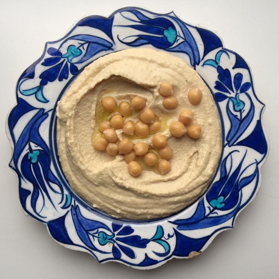 Directly Above View Of Fresh Hummus With Chick-Peas Served In Plate On White Background