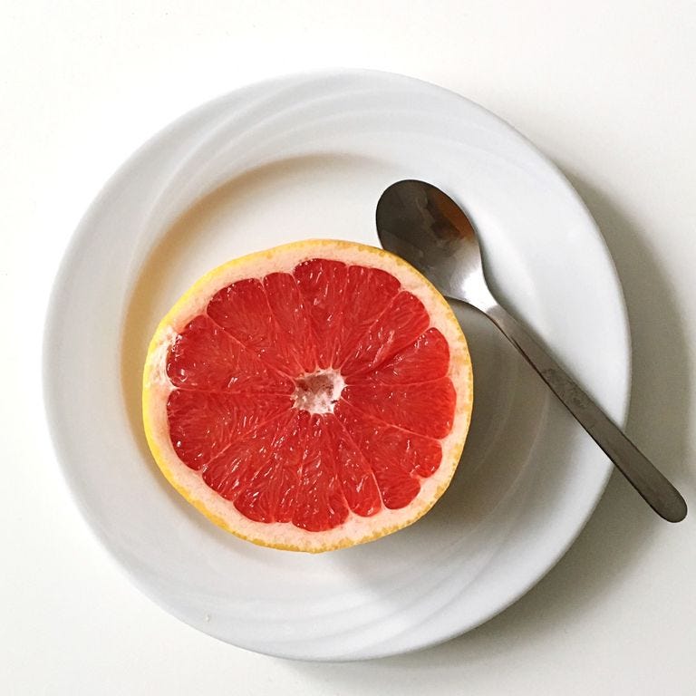 directly above view of grapefruit in plate on white background