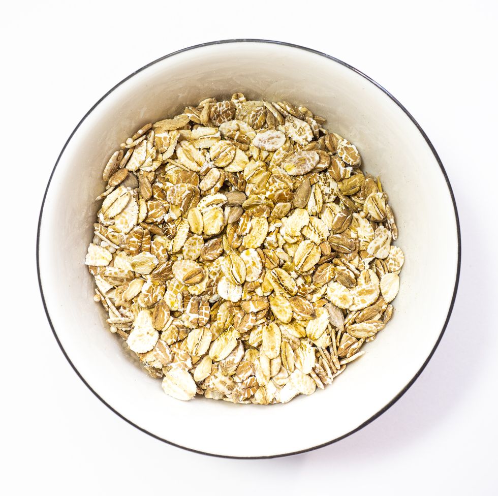 directly above view of oats flakes in bowl on white background